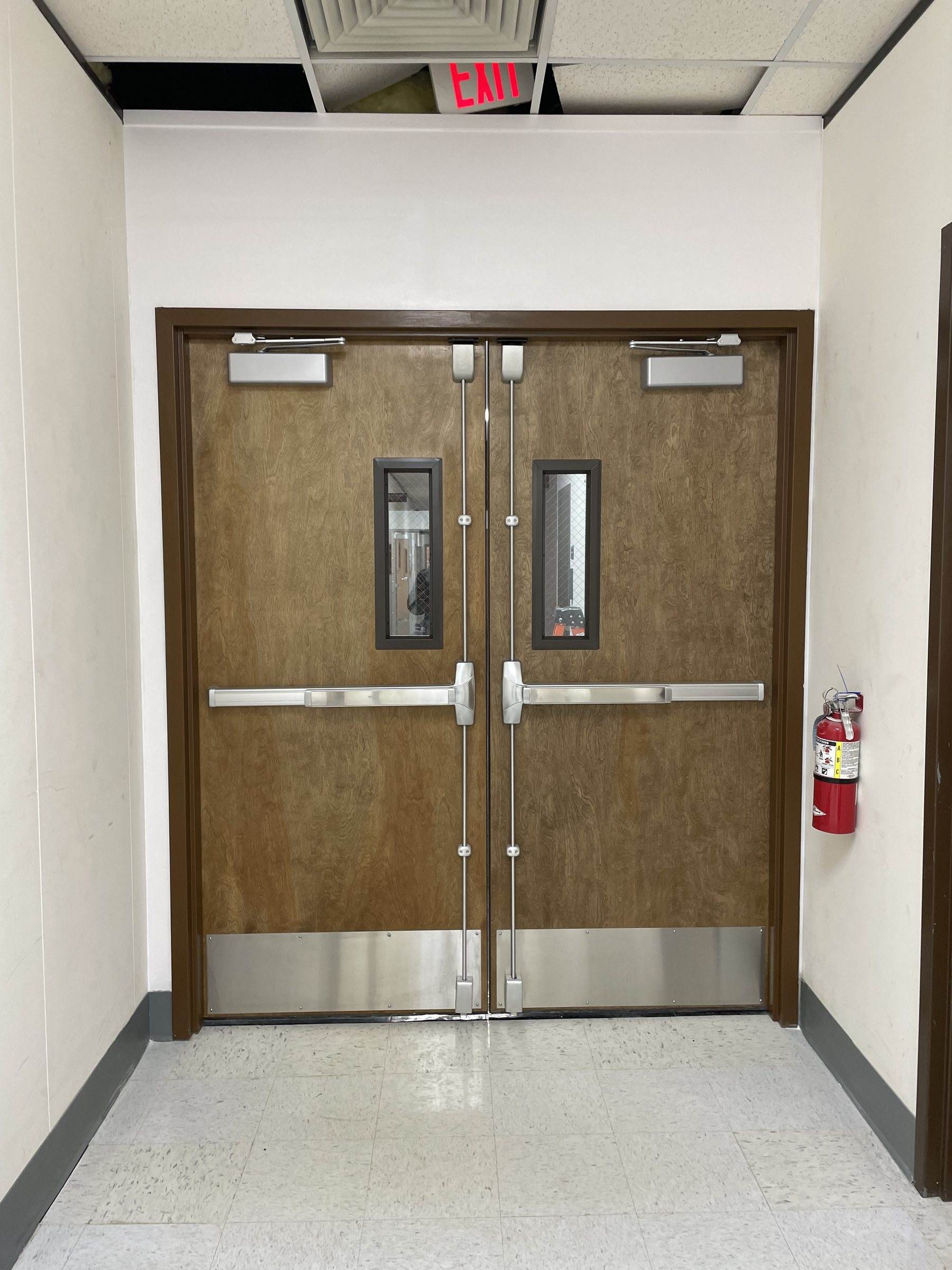 Wood double doors with vertical rod panic bars