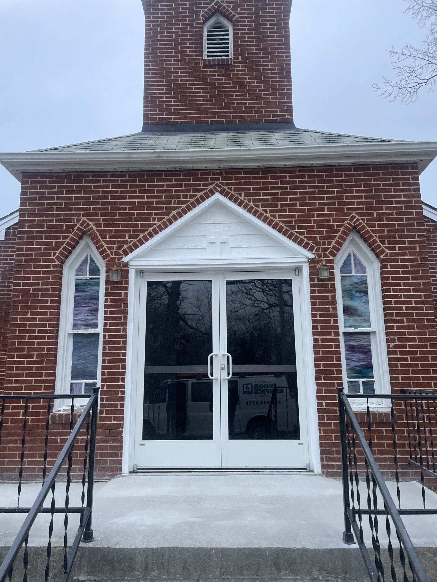 White double entry doors at a brick church